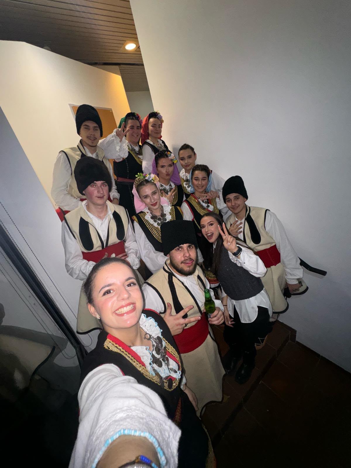 Mitglieder des KUD Ostrog in Tracht hinter der Bühne vor dem Auftritt